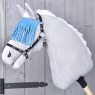 The Hobby Horse LarDen "Halter black with blue fringes" is shown on a gray plush hobby horse mounted on a wooden stick, set against a gray wooden wall.
