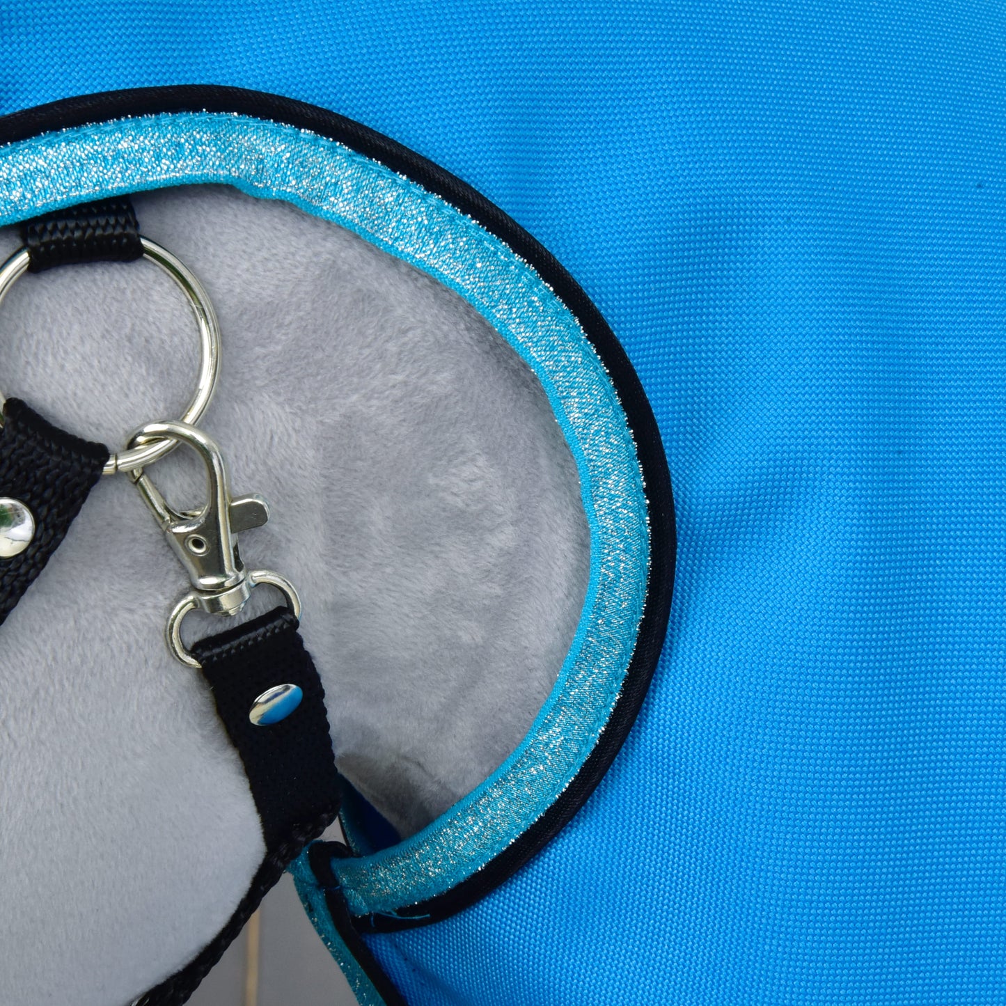 Gros plan sur l'Imperméable Bleu Ciel de Hobby Horse LarDen, avec tissu bleu, intérieur gris à doublure douce, sangle noire et anneau en D métallique avec fermoir, idéal pour une utilisation par tous les temps pour animal de compagnie.