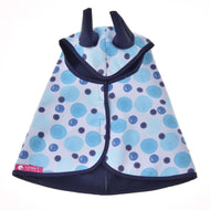 Regendecke Bubbles von Hobby Horse LarDen, ein blaues und dunkelblau gepunktetes Cape für Kinder mit Kapuze mit zwei spitzen Ohren, einem rosa Etikett nahe dem Saum, vor weißem Hintergrund.