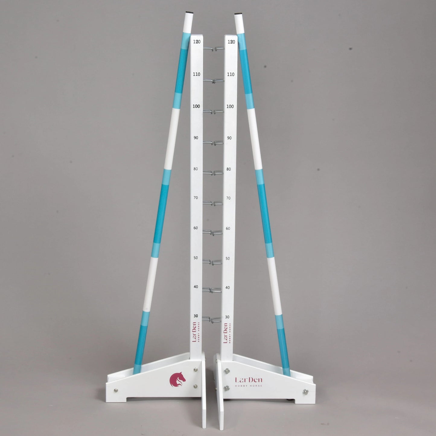 Jump 120 cm / 47 inch de Hobby Horse LarDen, obstacle réglable blanc et bleu avec deux poteaux, des bases blanches et une échelle centrale de hauteur de 10 à 180 cm. Idéal comme obstacle de cavaletti. Présenté sur fond gris uni.