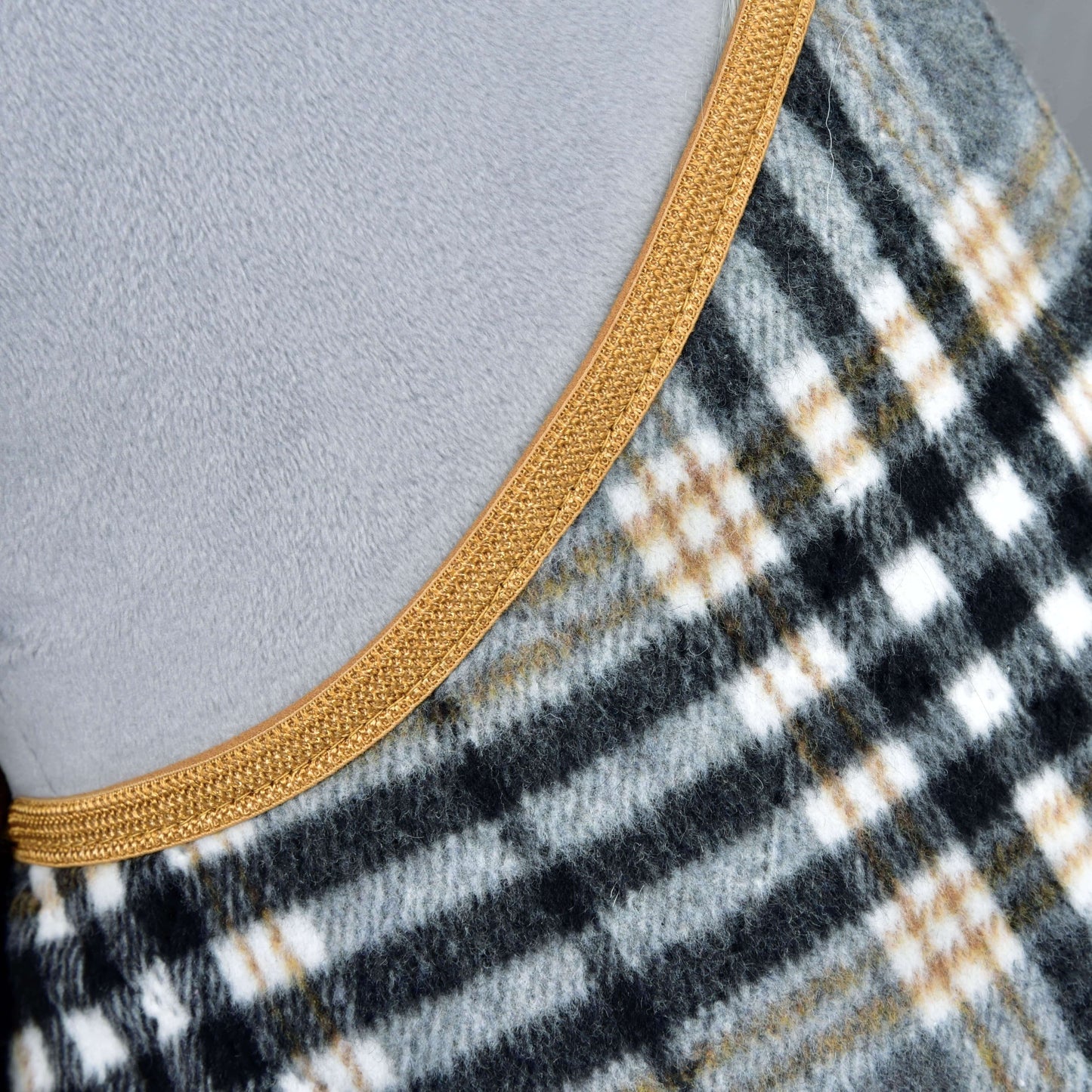 Close-up of the Hobby Horse LarDen "Set England Grey" blanket, featuring a black, white, and gray plaid with thin yellow lines and gold trim, set against a light gray background.