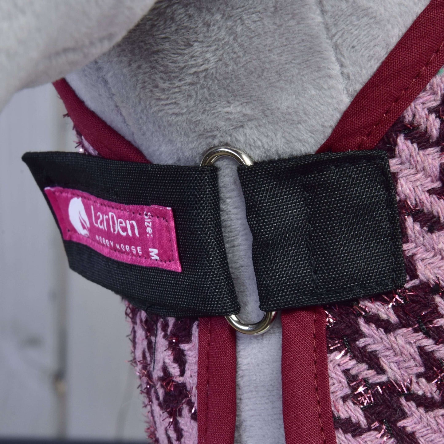 Nahaufnahme des Hundegeschirrs Set Harmony Elsa von Hobby Horse LarDen mit gewebtem Stoff in Bordeaux und Pink, schwarzem Riemen mit Metallring und pinkem LarDen M Etikett, im robusten Stil eines Pferdehalfters gestaltet.