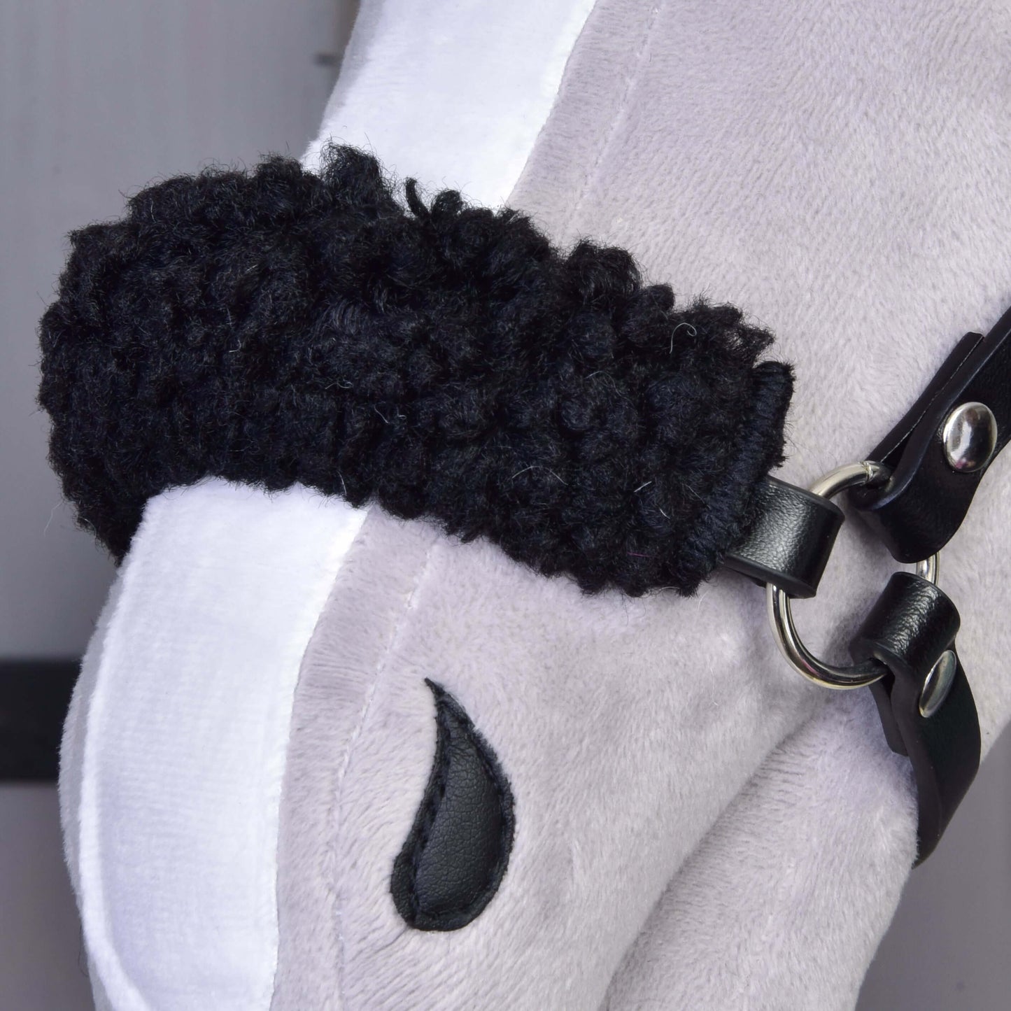 Nahaufnahme des Plüschs von Set Harmony Green Hobby Horse LarDen mit weichem Gesicht, weißem Nasenstreifen, schwarzem Zaumzeug, gesticktem Nüstern und flauschigem schwarzem Nasenriemen.