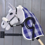 The Set Harmony Victory by Hobby Horse LarDen features a gray hobby horse with black halter and reins, a blue and white plaid stable blanket, and white faux fur on ears and neck, mounted on a wall with gray wood paneling background.