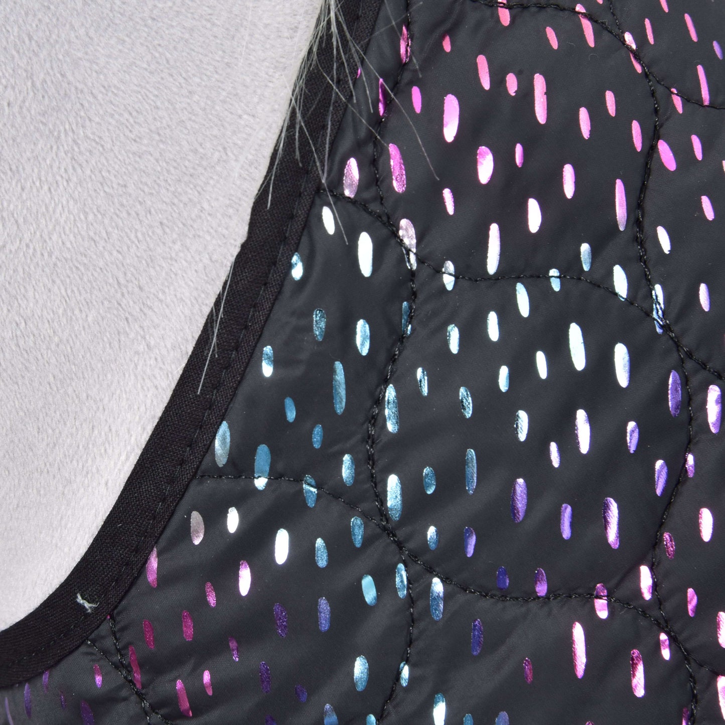 Gros plan sur l'Ensemble Rêveur de Hobby Horse LarDen : tissu noir matelassé avec points ovales brillants roses, violets et bleus, bordé de noir, idéal comme couverture ou décoration pour Hobby Horse.