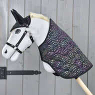 Set Dreamy Hobby Horse von Hobby Horse LarDen mit weißem Körper, schwarzem Zaumzeug und schwarzen Ohren sowie einer bunt gepunkteten Decke, vor einer grauen Holzwand.