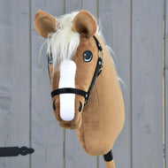 Hobby Horse Star mit schwarzem Halfter von Hobby Horse LarDen mit karamellfarbenem Fell, weißer Blesse, cremefarbener Mähne und schwarzem Halfter vor grauem Holz-Hintergrund.