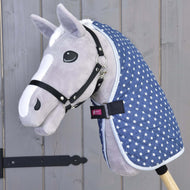 A gray plush hobby horse with a black halter and the Hobby Horse LarDen Stable Blanket Star, a blue blanket with star patterns, shown against a wooden background.