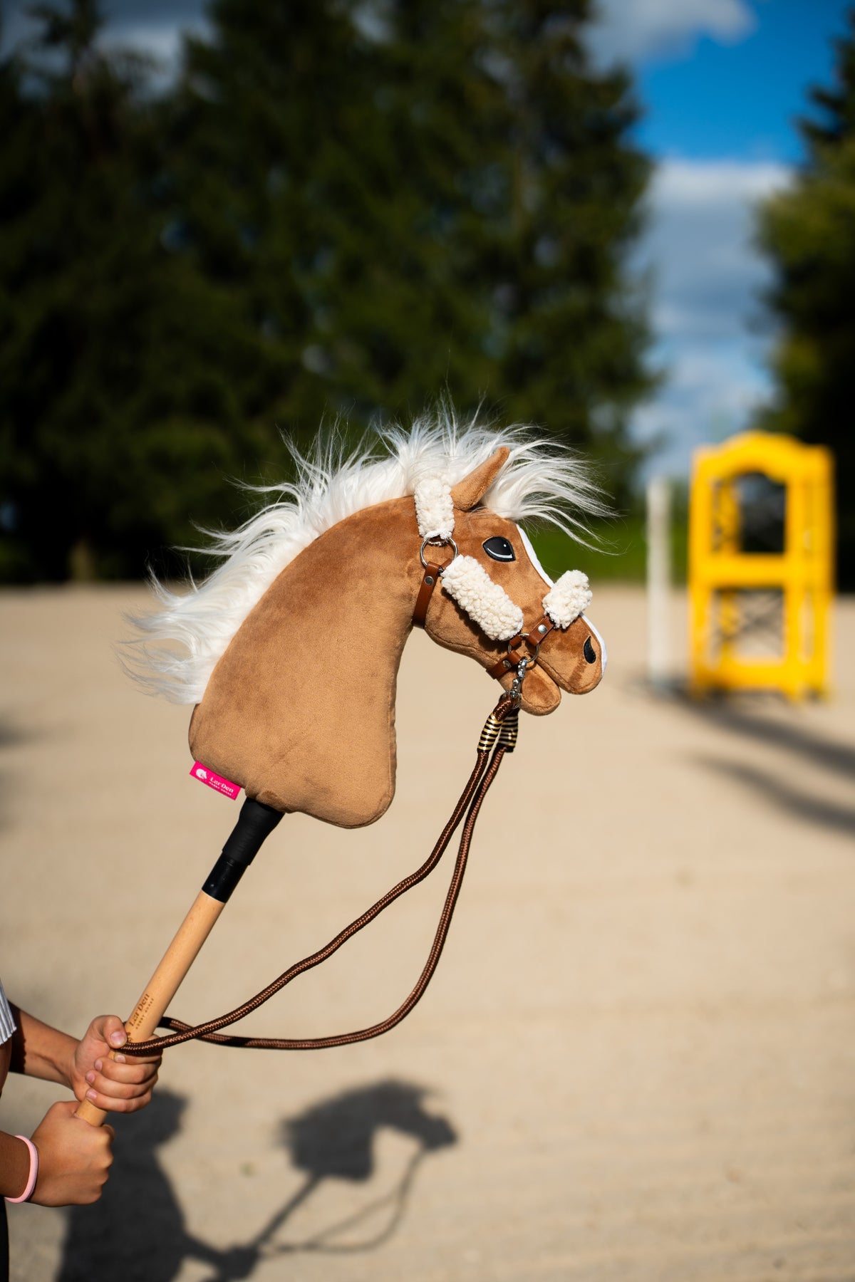 Hobby Horse Zügel Vivaldi, braune Seilzügel an einem hellbraunen Hobby Horse mit weißer Mähne im Freien