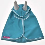 Die Hobby Horse LarDen Regendecke Turquoise hat hellblauen Besatz, weiße Paspelierung und ein rosafarbenes Markenetikett an der unteren linken Kante. Von einem Welpen mit aufrechten Ohren getragen, ist sie die perfekte Regendecke für stilvolle Hunde.