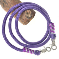 Rênes Viola de Hobby Horse LarDen, avec corde en polypropylène violette torsadée, mousquetons pivotants et enroulement de fil violet et blanc, idéales comme rênes faites main pour les fans de Hobby Horse, présentées sur un fond de bûche en bois.