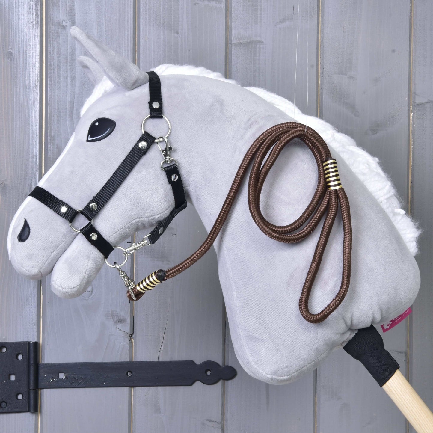 Hobby Horse - rayure corde Vivaldi de Hobby Horse LarDen suspendu à un support mural en bois sur fond en bois gris.