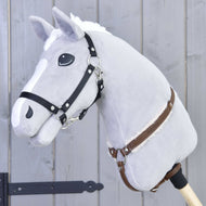 The Hobby Horse LarDen "Breastgirth with fur Walnut" is displayed on a plush gray hobby horse with a white mane, black bridle, leather reins, and wooden stick, set against a gray wooden background.