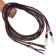 Die Hobby Horse LarDen Offene Westernzügel Kansas sind dunkelbraune Zügel, die um einen Holzstab geschlungen sind, mit Karabinerhaken mit pinken und weißen Fadenakzenten an einem Ende und Lederklatschen am anderen.