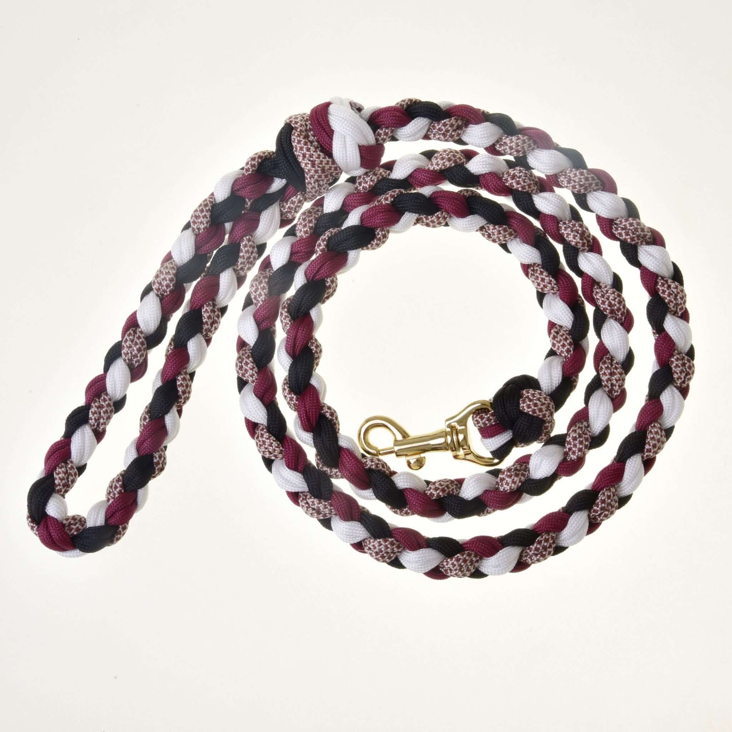 Hobby Horse - Cordelette tressée noir/blanc/bordeaux de Hobby Horse LarDen, en noir, blanc et bordeaux avec mousqueton en métal doré, enroulée sur un fond blanc — idéale comme équipement élégant pour Hobby Horse ou comme cordelette polyvalente.