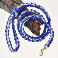 The Hobby Horse LarDen braided lead rope in white/blue, featuring a brass clasp, is coiled around a tree branch and shown against a white background—ideal for hobby horse activities or as a dog leash.
