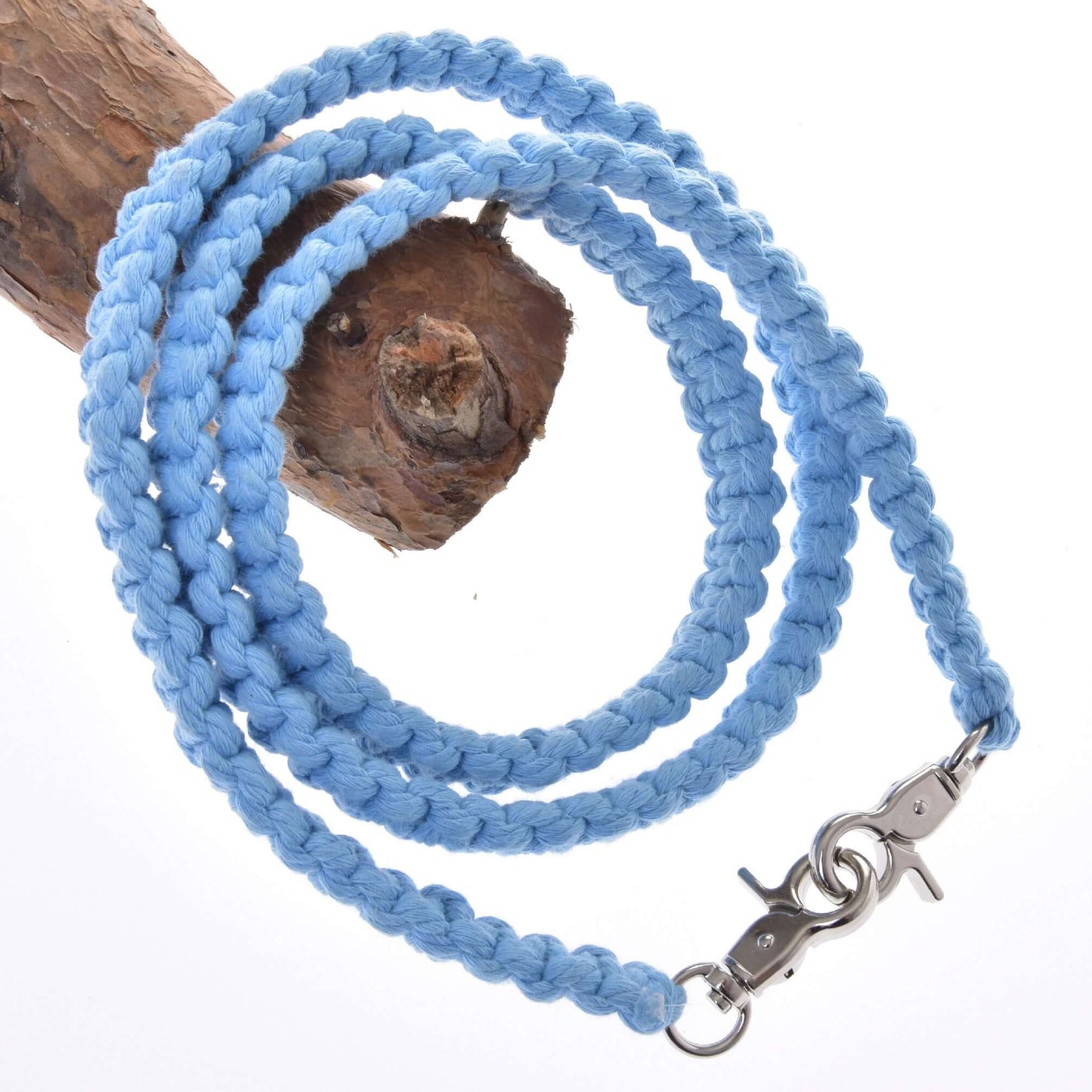 The Rope set Cotton Blue (size M) by Hobby Horse LarDen features a blue cotton braided leash with a metal clasp, coiled on a tree branch—ideal for pairing with your handmade halter or hobby horse accessories.