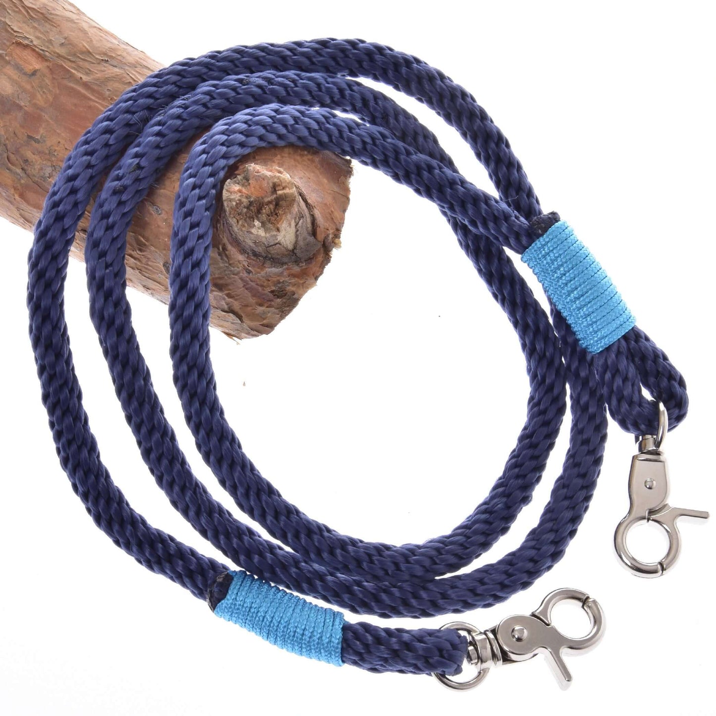 Ensemble de corde bleu foncé de Hobby Horse LarDen, avec longe bleu foncé enroulée, mousquetons métalliques aux deux extrémités, chacun entouré de fil bleu vif, présenté sur une branche en bois brun clair, accessoire d’équitation élégant.