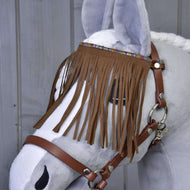 The Hobby Horse LarDen “Halter brown with fringes” is shown on a gray plush hobby horse with a white mane, featuring decorative browband fringes, set against a wooden background.