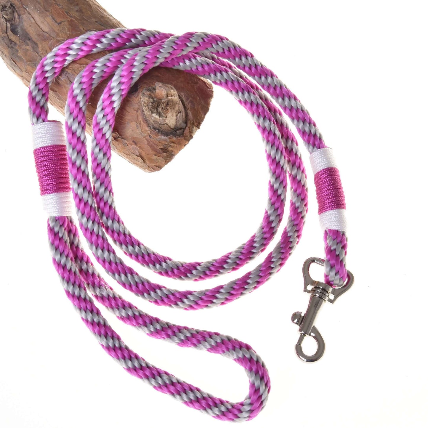 Hobby Horse LarDen Hobby Horse - Führstrick Streifen rosa mit rosa, weißen, lila und schwarzen Flechtungen und Metallkarabiner, auf Holz aufgewickelt vor weißem Hintergrund.